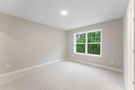 (Photo of a similar home, actual finishes may vary) Situated on the second floor, this secondary bedroom features a walk-in closet offering ample space for wardrobe storage.