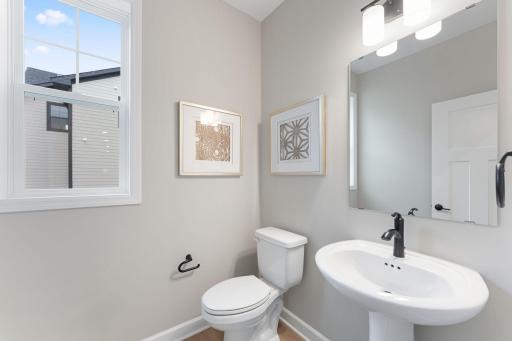 (Photo of a similar home, actual finishes may vary) Adjacent to the laundry room, this powder room is readily available for day and nighttime use.
