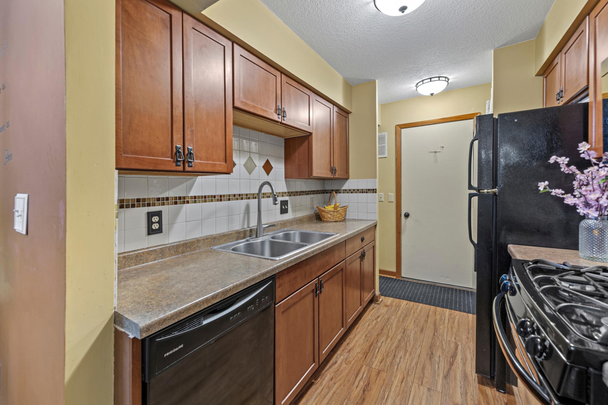 Galley kitchen with updated cabinetry and gas stove