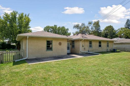 Back of stucco home with patio