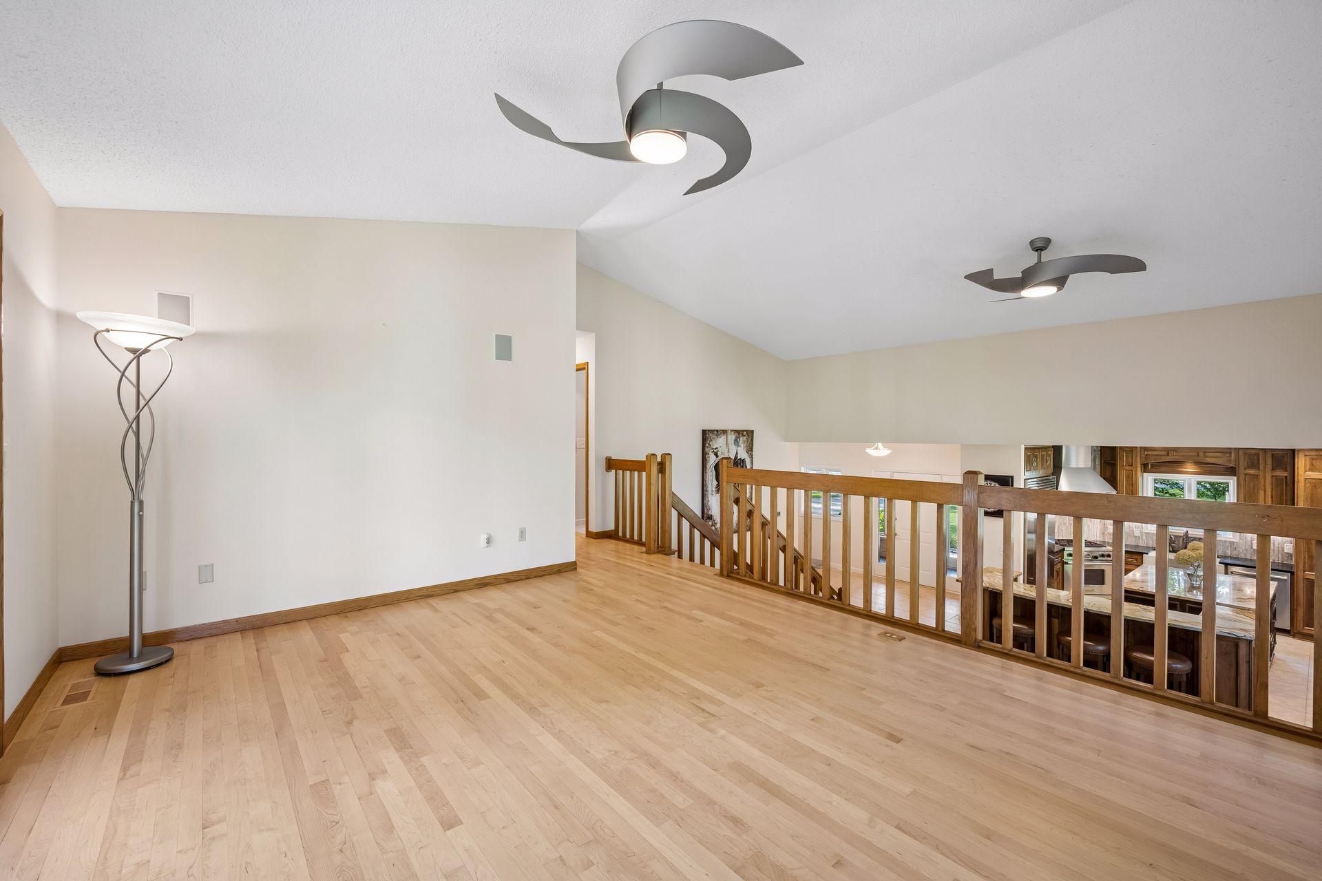 Living room on the upper level features gleaming hardwood maple floors
