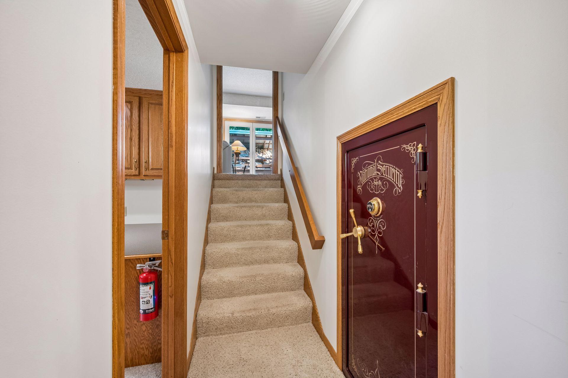 Hallway leading to the lowest level. Liberty safe will remain with the home.