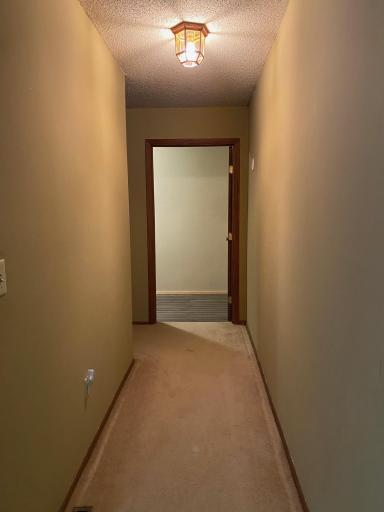 Walking down hallway on the left side of the living room to the storage room and master bedroom