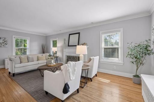 Bright living room with hardwood floors and multiple windows.