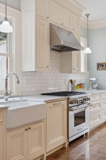Chef's kitchen features professional-grade range and subway tile backsplash