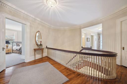 The staircase's elegant railing continues the home's signature curved design upstairs