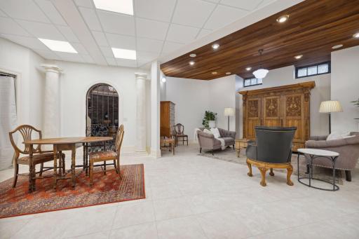 Lower-level recreation space with warm wood-beamed ceiling