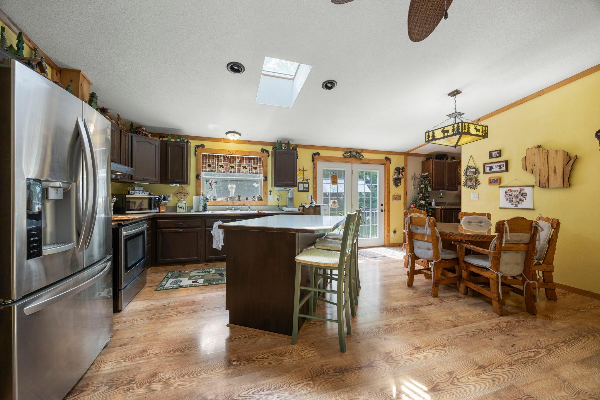The renovated kitchen includes stainless appliances, a new french wood door & a window overlooking the backyard patio.