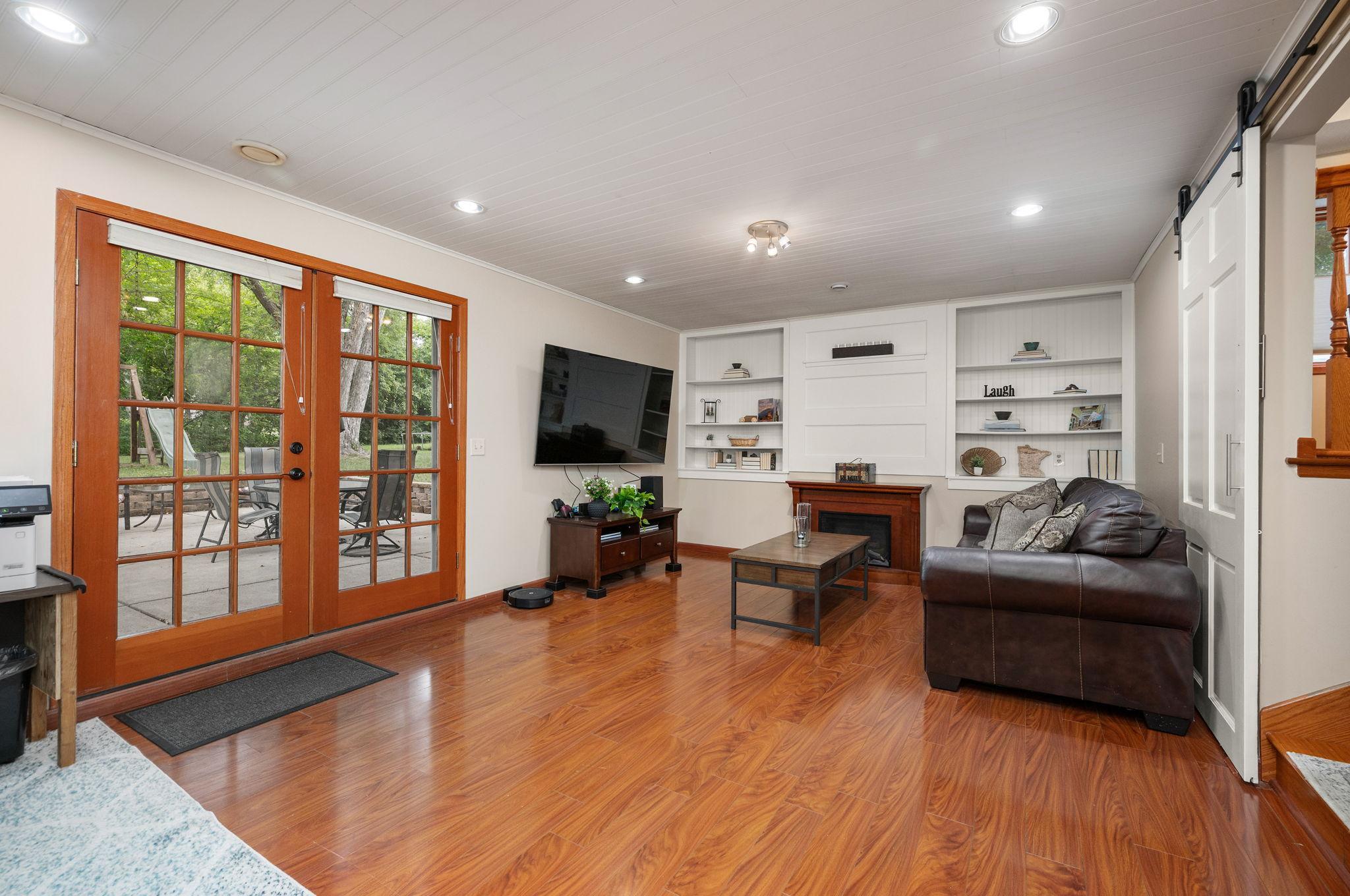Entertaining area complete with built-in media cabinetry, recessed lighting, and direct patio/backyard walkout access