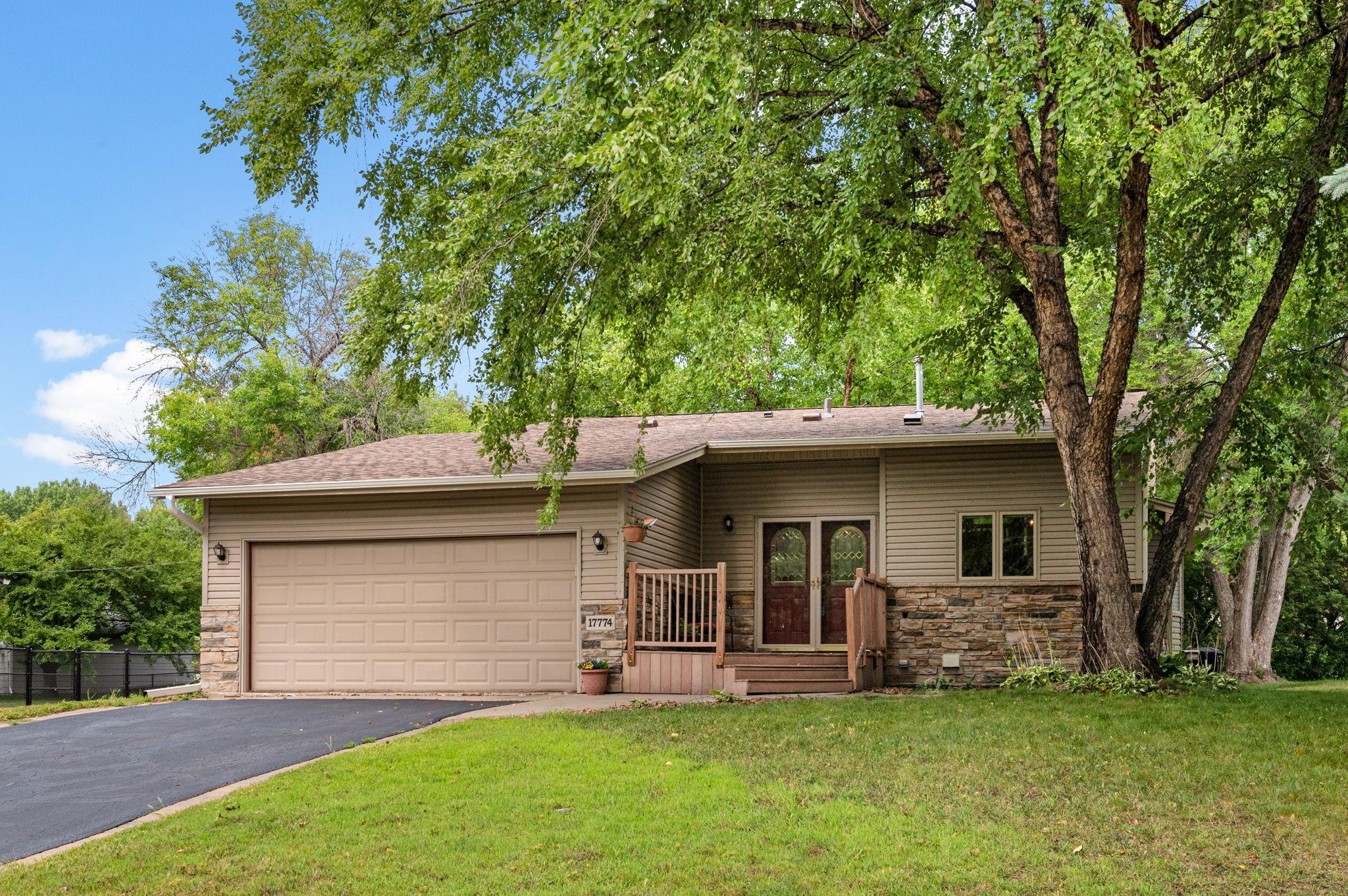 Welcome home to 17774 Weaver Lake Dr! Beautiful single-family home featuring classic stone accents, mature trees, and an attached garage