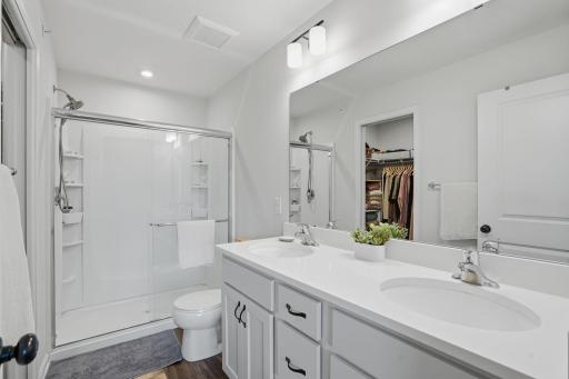 The primary bath offers a spacious dual vanity, walk-in shower, and everyday comfort.