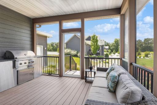 Screened porch off the kitchen with built-in grill and mounted TV