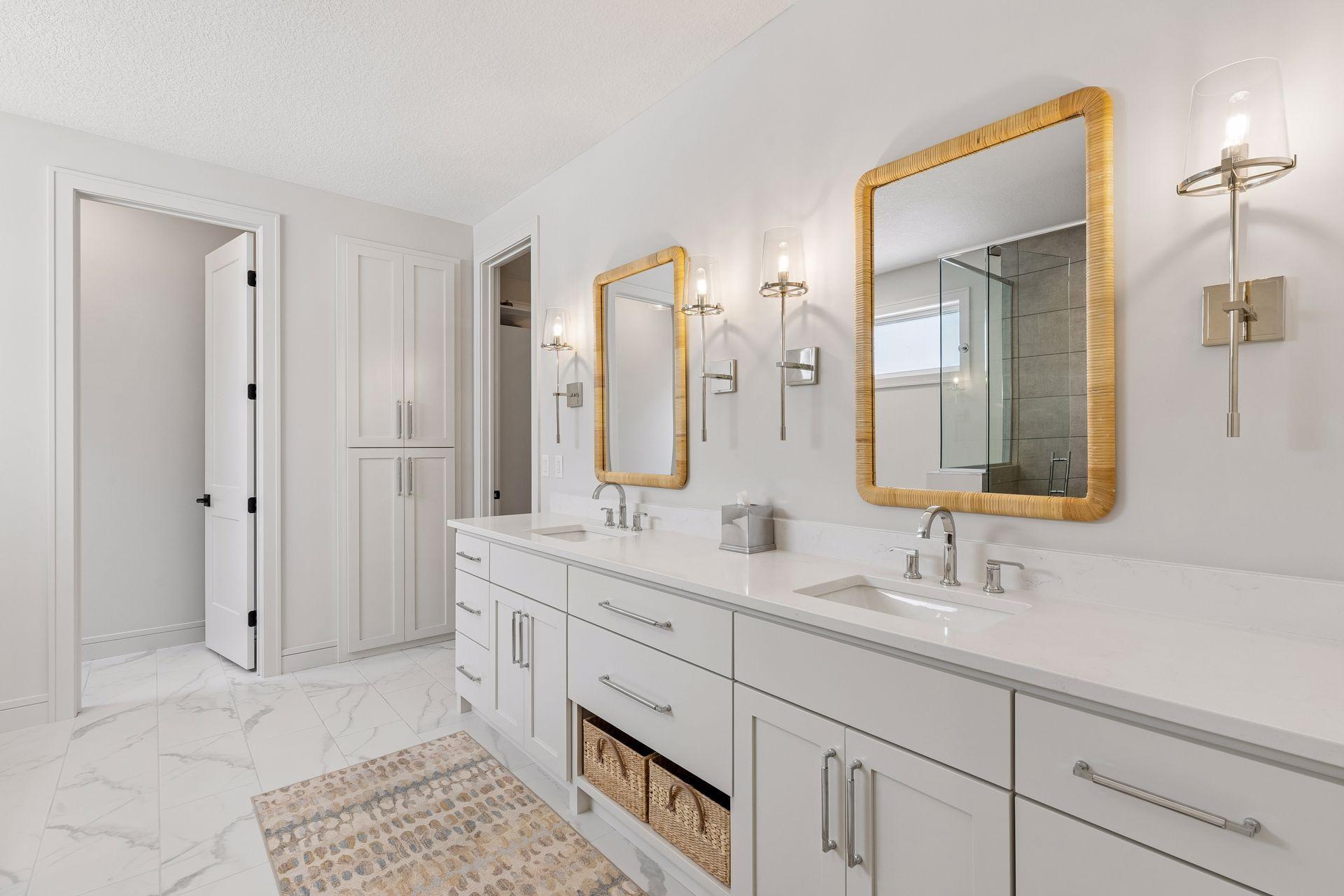 Primary bath with double vanity, custom framed mirrors, ample storage, and large linen closet.