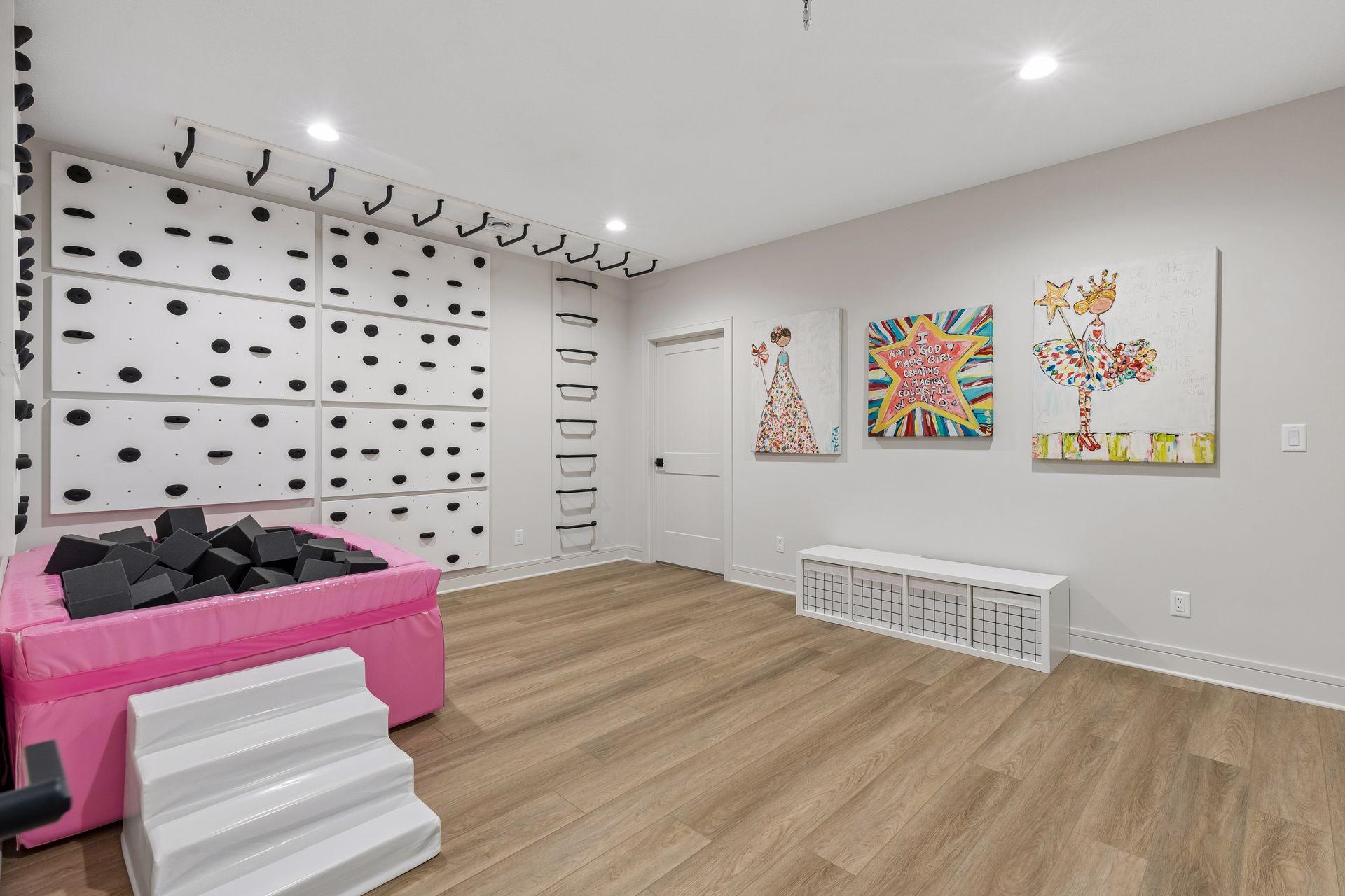 The lower level exercise/flex room was turned into a fun, large-motor play space for kids! The rock climbing wall and monkey bars can stay with the home, or be removed by the seller.
