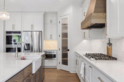 Walk-in pantry with melamine shelving and LG appliances.