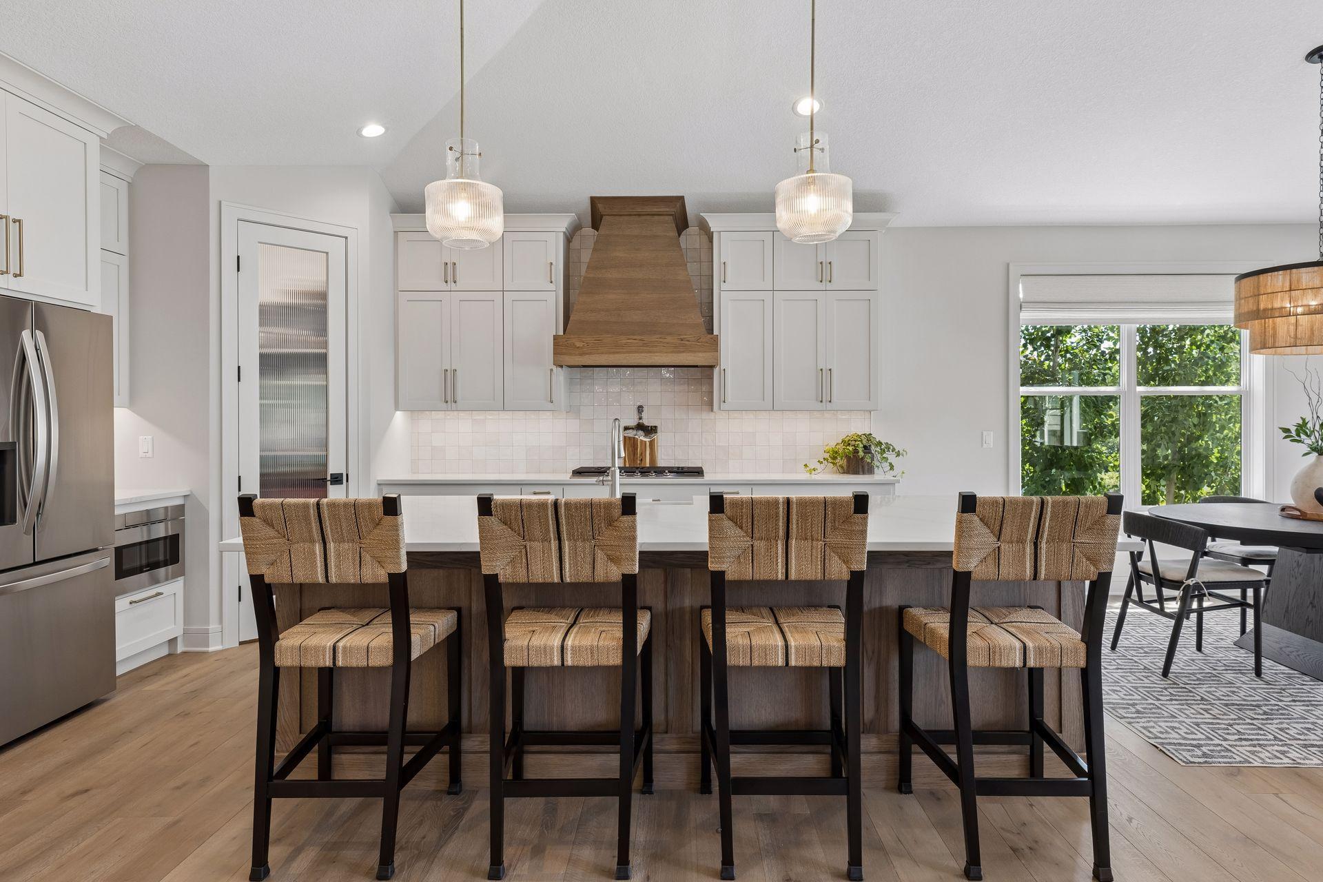 Gourmet kitchen with custom cabinets to the ceiling, walk-in pantry, under cabinet lighting, soft close doors and drawers, and wood hood above the cooktop.