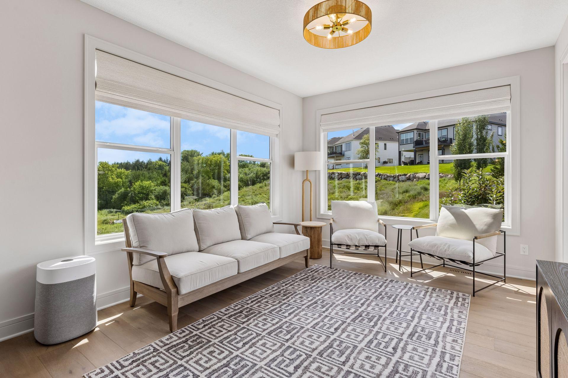 Sun-filled sunroom surrounded by expansive windows and featuring custom electric roller shades.