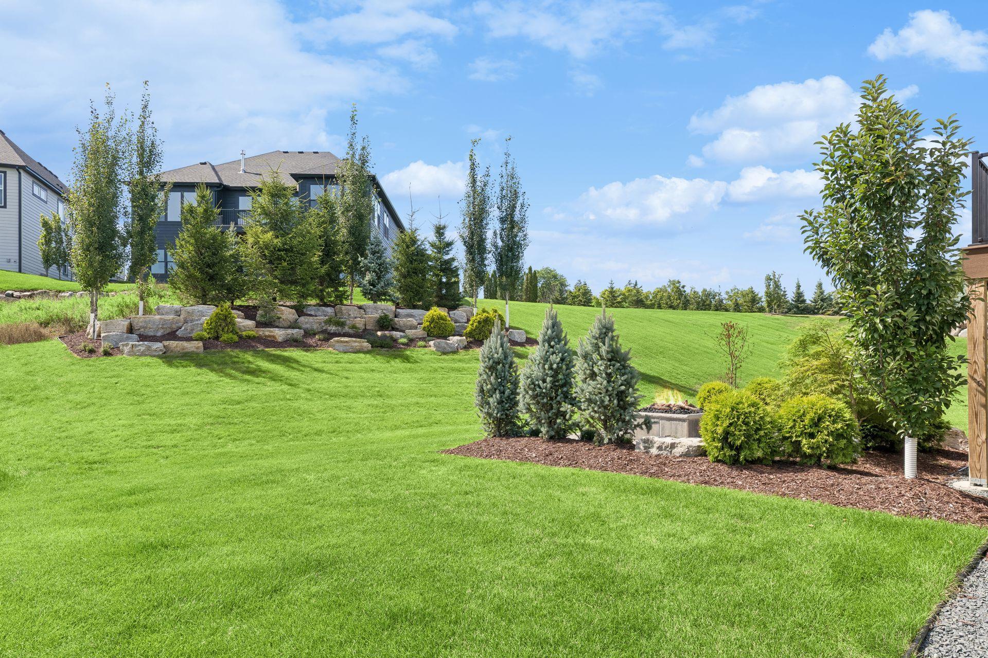 The tree-lined landscaping berm with outcroppings allows backyard privacy.