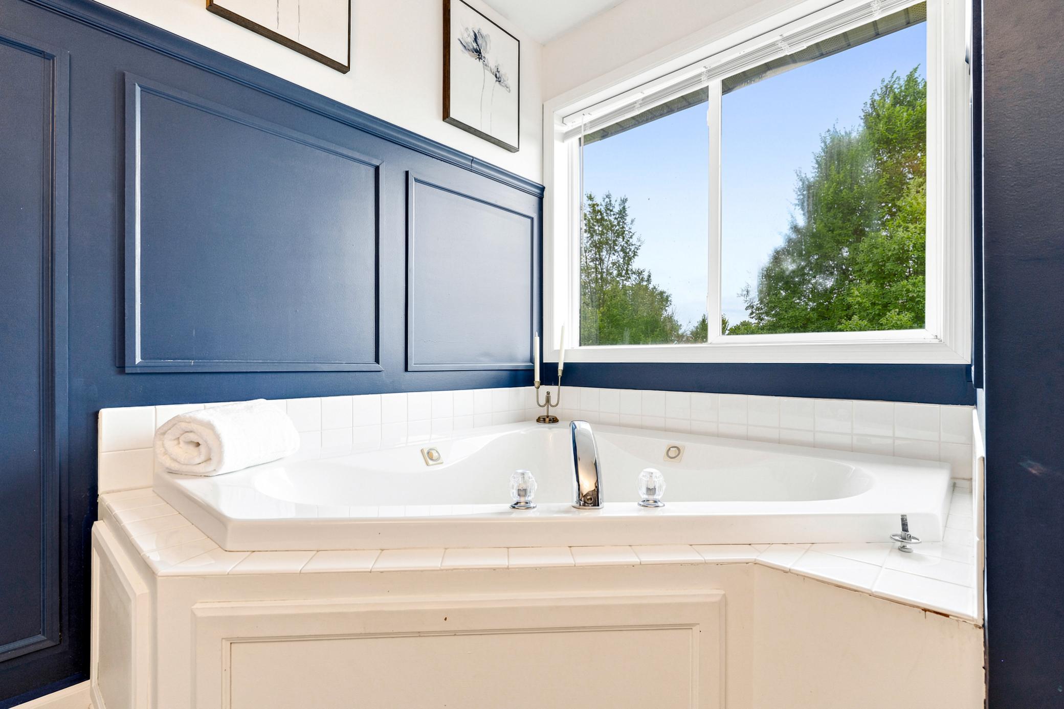 Unwind in the relaxing jetted soaking tub, perfectly positioned beneath a large picture window that brings in natural light and peaceful views.