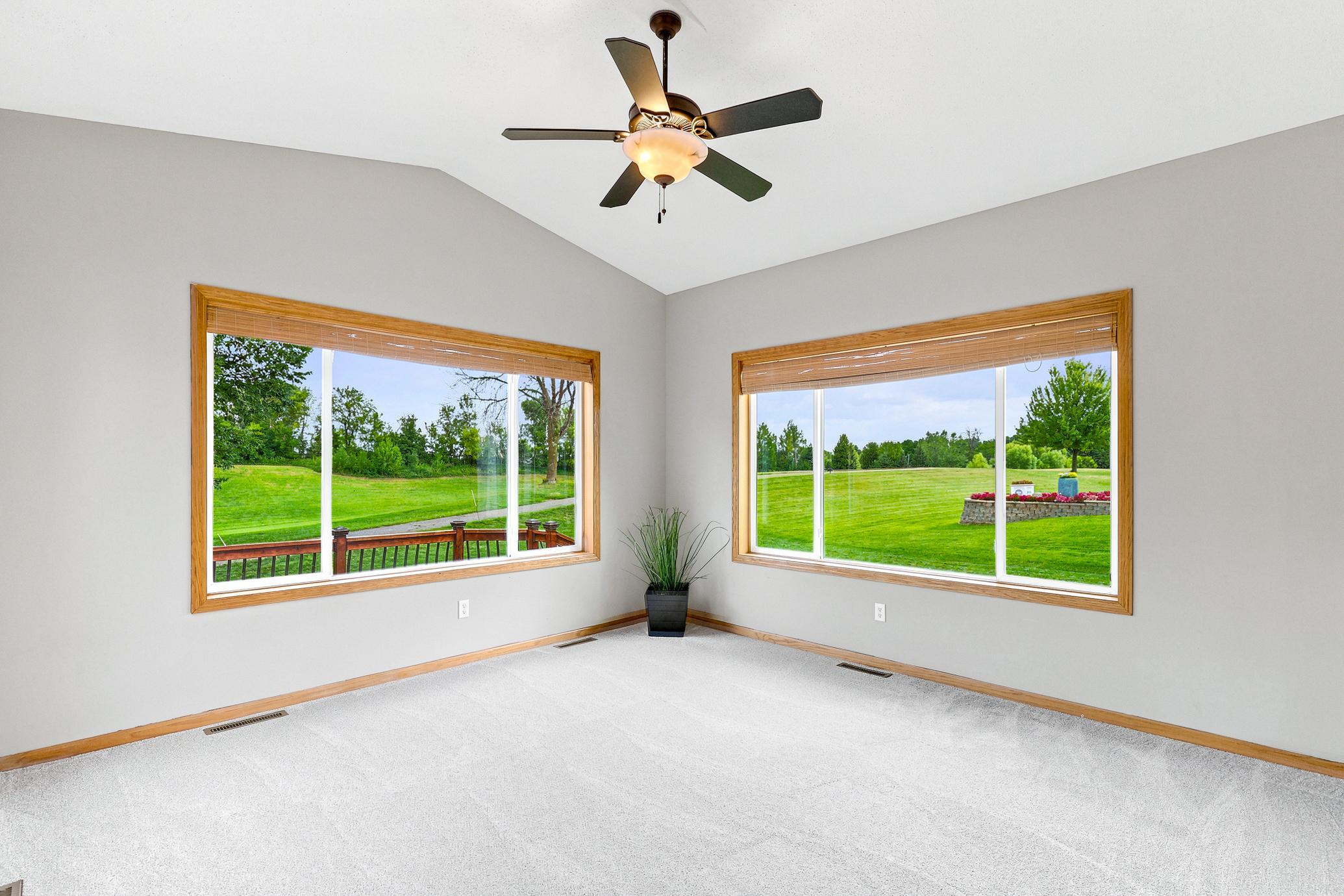 The bright and inviting sunroom is surrounded by walls of windows, offering panoramic golf course views and a peaceful retreat to enjoy every season.