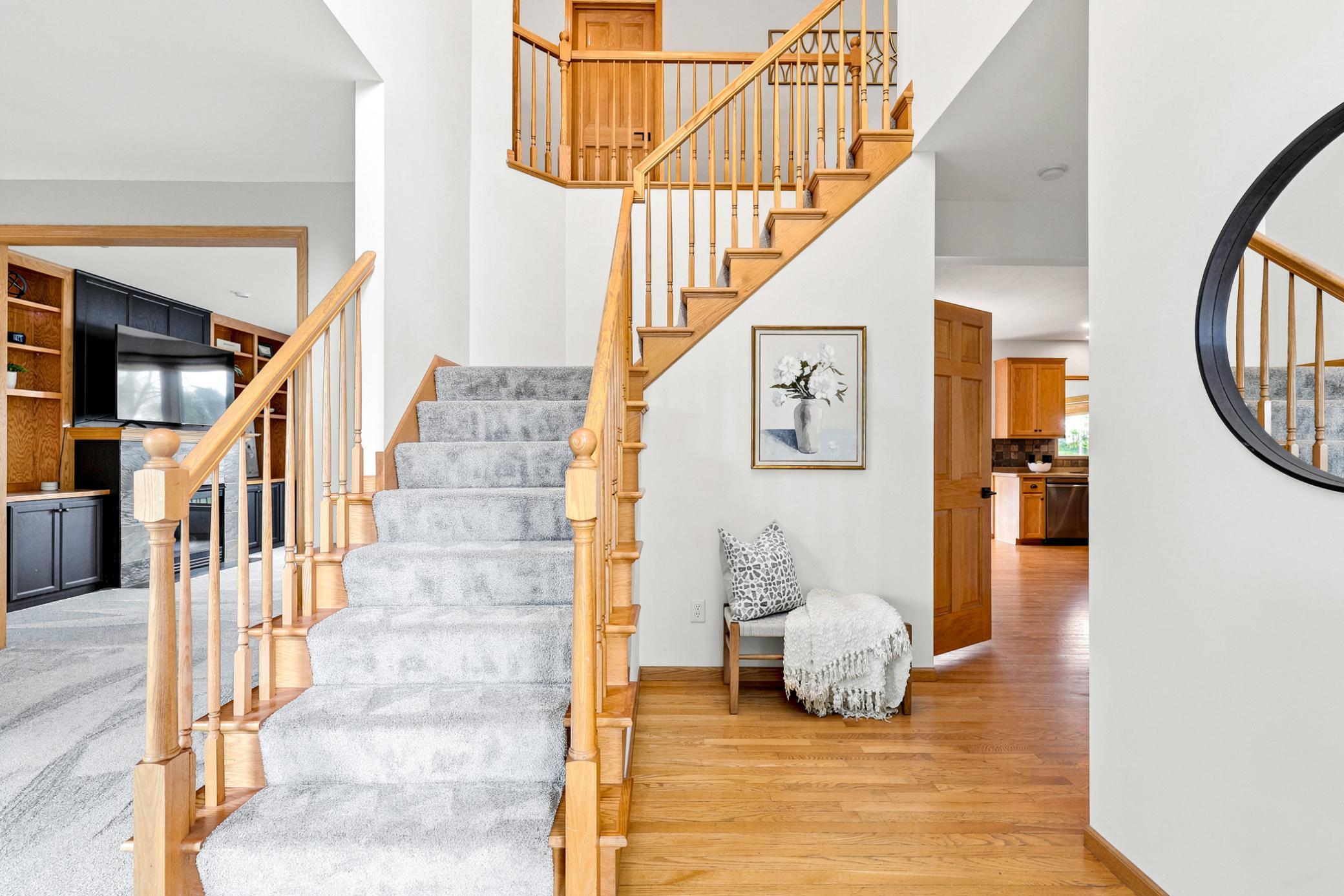 An impressive two-story foyer welcomes you with soaring ceilings, rich hardwood floors, and an elegant open staircase, creating a warm and inviting first impression.