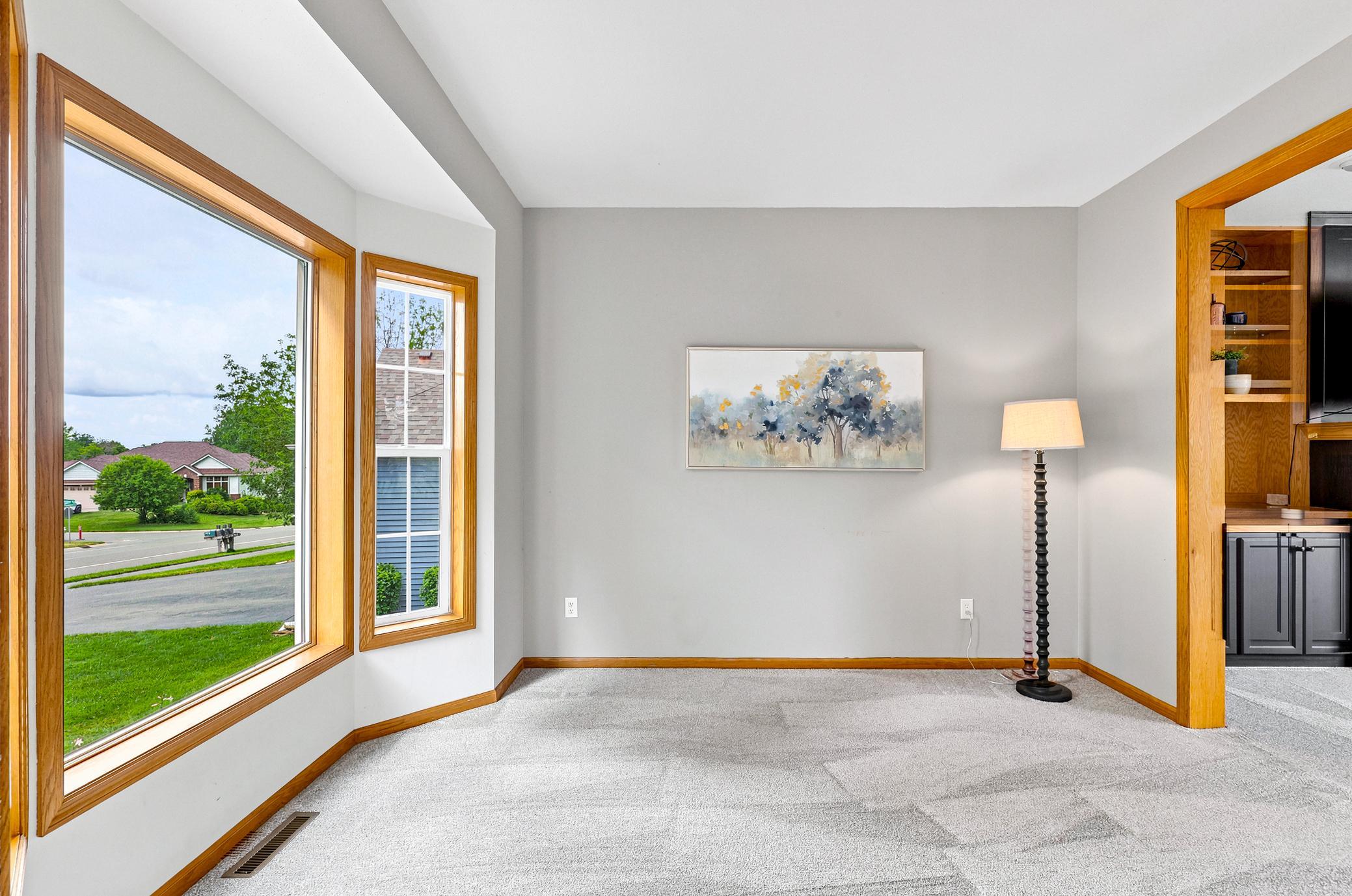 The sun-filled formal living room features a beautiful bay window, plush new carpeting, and the perfect setting for entertaining guests or enjoying a quiet retreat.
