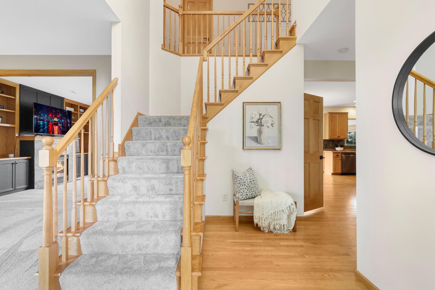 An impressive two-story foyer welcomes you with soaring ceilings, rich hardwood floors, and an elegant open staircase, creating a warm and inviting first impression.