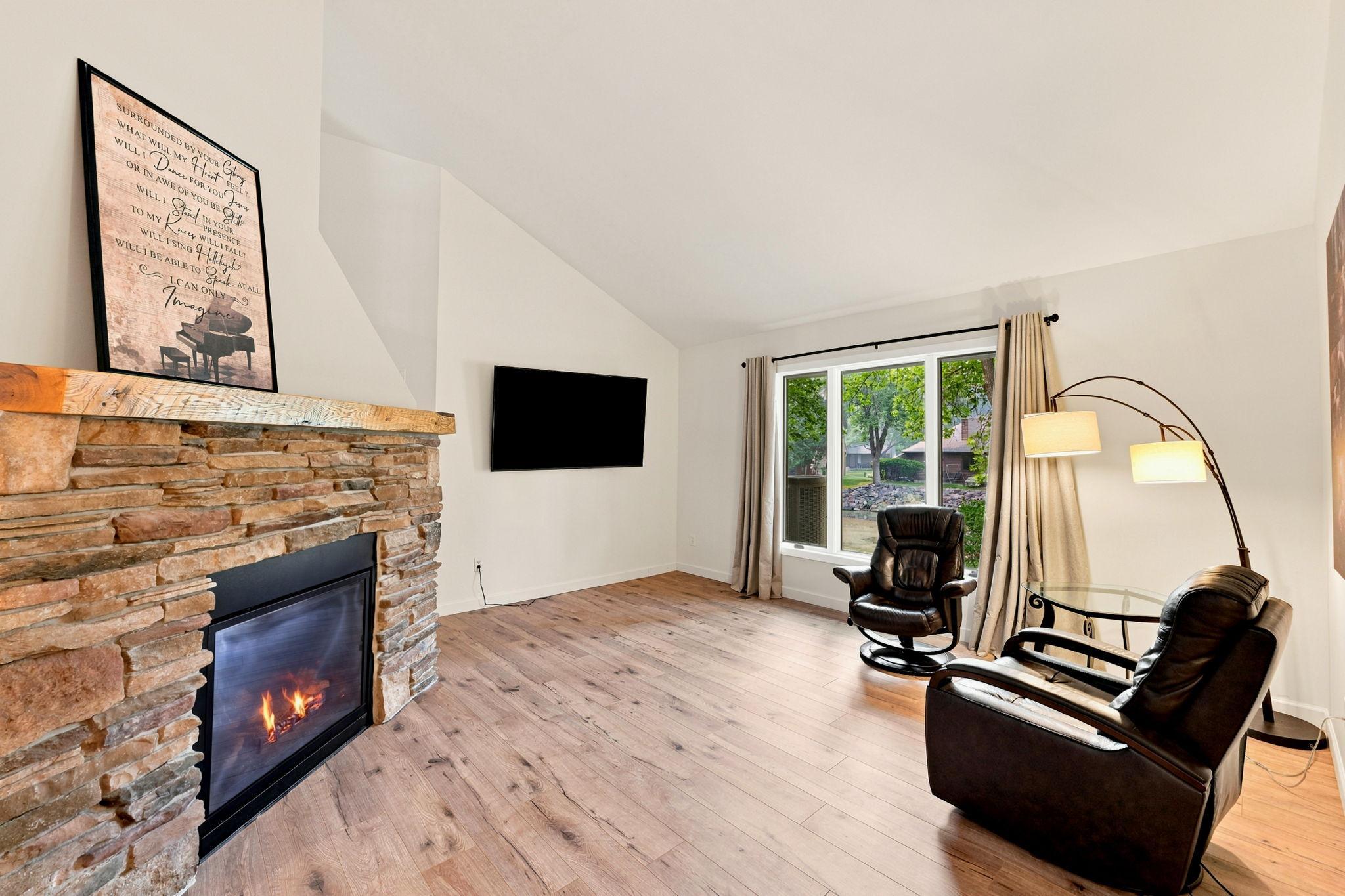Cozy up to the pretty stone fireplace, featuring a dramatic mantel and wall display space!