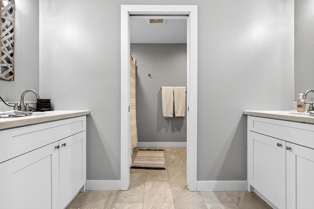 Basement 3/4 bathroom features new flooring, dual sinks and pocket door to the toilet/shower for added privacy and functionality for those with multiples getting ready at the same time!