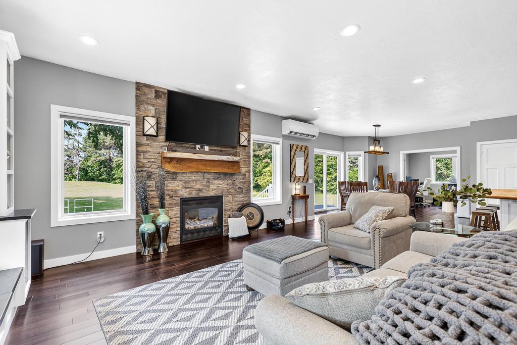 The cozy living room is centered around the fireplace featuring brick accent and wooden mantle