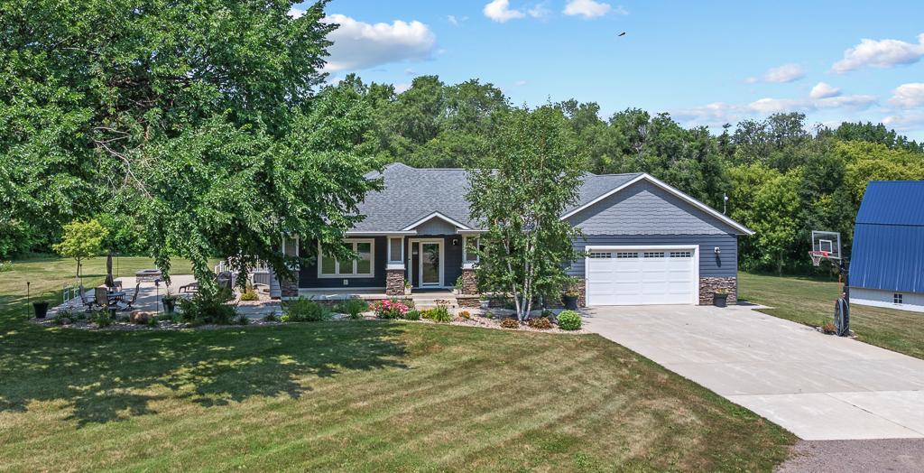 Absolutely beautiful landscaping surrounds the front of the home, while the concrete driveway extends as a sidewalk to the front entry and to the patio.