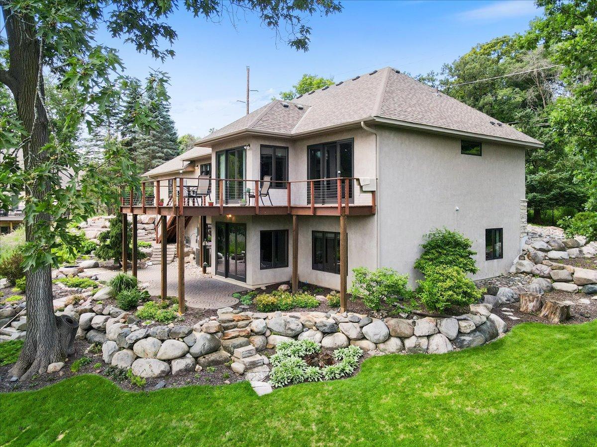 A masterful balance of premium hardscaping, manicured lawns, and professionally designed plantings seamlessly blends with the wooded backdrop, creating a private, park-like retreat.