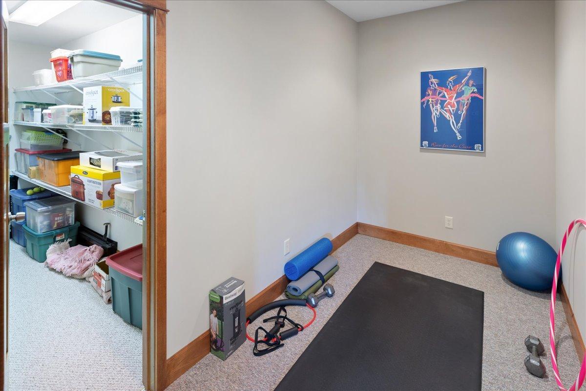 An impressive flex area currently used as a fitness area with an expansive attached storage room. This versatile area provides endless possibilities for recreation, hobbies, wellness, or customized needs while adding valuable a function in the home.