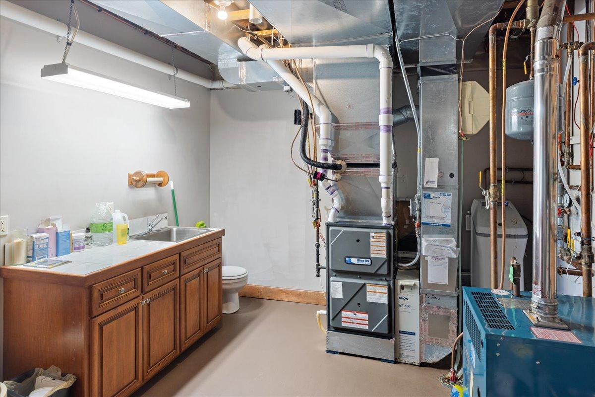 The mechanical area featuring more built-in cabinetry, organized storage, and a convenient bathroom facility—an uncommon level of functionality and convenience not often seen in residential construction.