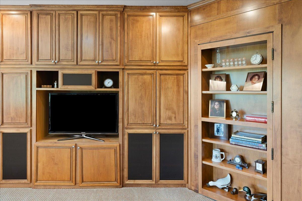 One of the home's more unique design features is the secret bookcase hidden door, a creative architectural element that blends seamlessly into the décor while adding a touch of intrigue, personality, and functionality. See next photo with door open.