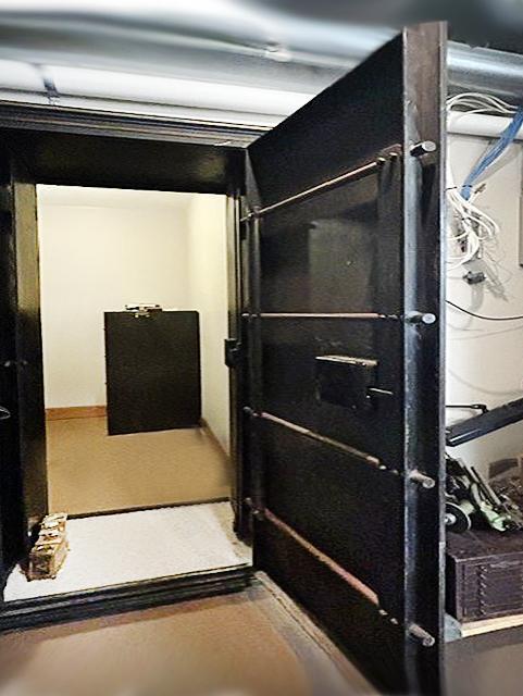 The secure vault room is exceptionally well built, enclosed by concrete walls for outstanding protection. Shown with the vault door open, secure storage for firearms, important documents, collectibles, or other prized possession.