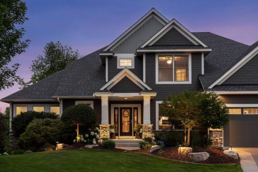 As the sun sets, this stunning exterior comes to life with a warm, inviting glow and beautifully illuminated grounds.