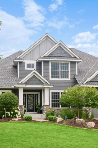 The property has thoughtfully designed landscaping with a rich mix of trees, shrubs, and perennials, enhanced by clean concrete edging and automatic evening lighting.