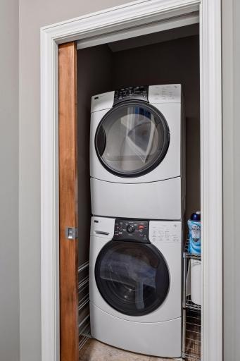 A tucked-away stackable washer and dryer behind a pocket door adds everyday convenience to the primary suite.