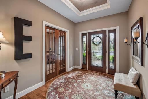 The welcoming entry features an elegant tray ceiling with crown molding detail and a convenient coat closet.