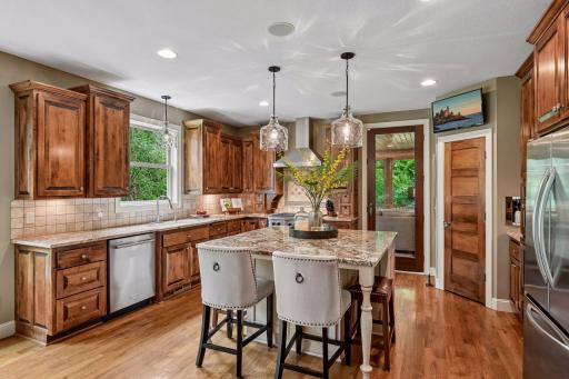 A bright, open kitchen showcasing extensive maple cabinetry and a well-placed pantry.