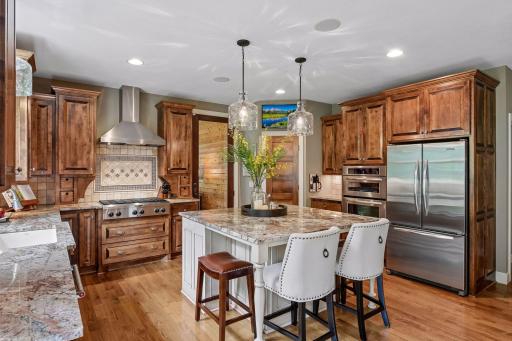 Complete with a 5' x 5' island, stainless steel appliances, and easy access to the screened porch beyond