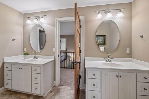 The upper-level bath is a Hollywood-style bath with ceramic tile flooring, two separate 4' vanities in the main room, and a separate water closet.