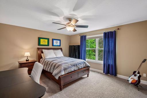 The first upper-level bedroom looks out to the backyard and includes a ceiling fan.