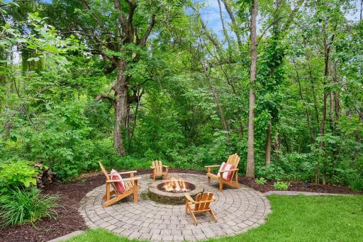 The 15' paver patio, surrounded by mature trees, includes a built-in firepit.