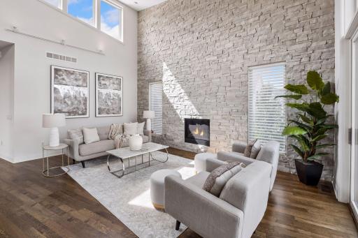 A true lakefront showpiece featuring a soaring floor-to-ceiling stacked stone accent wall, elegant fireplace and walls of windows that fill the great room w/natural light. An unforgettable setting for lakeside gatherings, relaxation and sunset views.