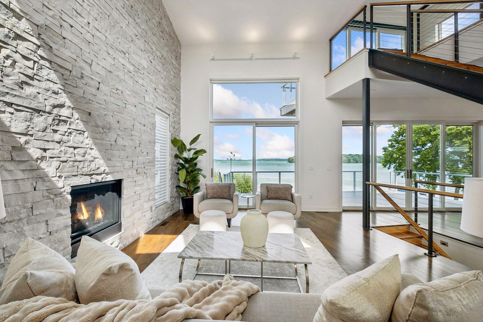 Wake up to shimmering lake views and unwind beside the glow of the fireplace as sunlight pours through walls of windows. Soaring ceilings, a dramatic stone feature wall and seamless indoor-outdoor living capture the essence of lake life at its finest
