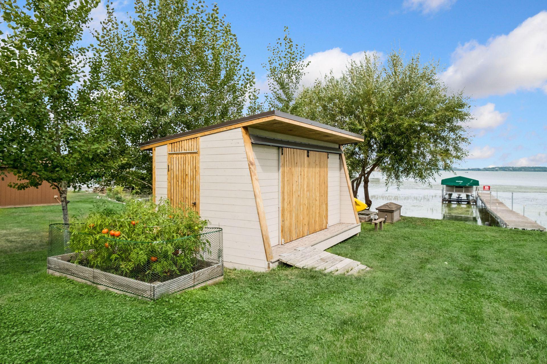 Custom boat house shed with sliding doors for ease access from all four sides. Plenty of room for yard games, garden and pure enjoyment at this home with NOA HOA!