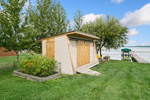 Custom boat house shed with sliding doors for ease access from all four sides. Plenty of room for yard games, garden and pure enjoyment at this home with NOA HOA!