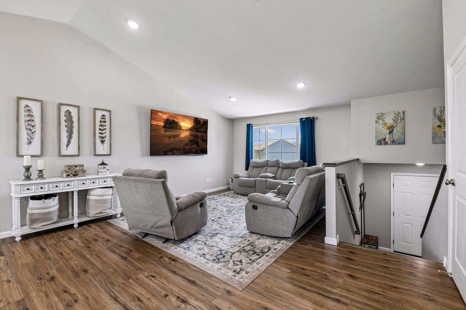 Vaulted main level living room open to kitchen with wide staircase entry. Knockdown ceilings throughout.